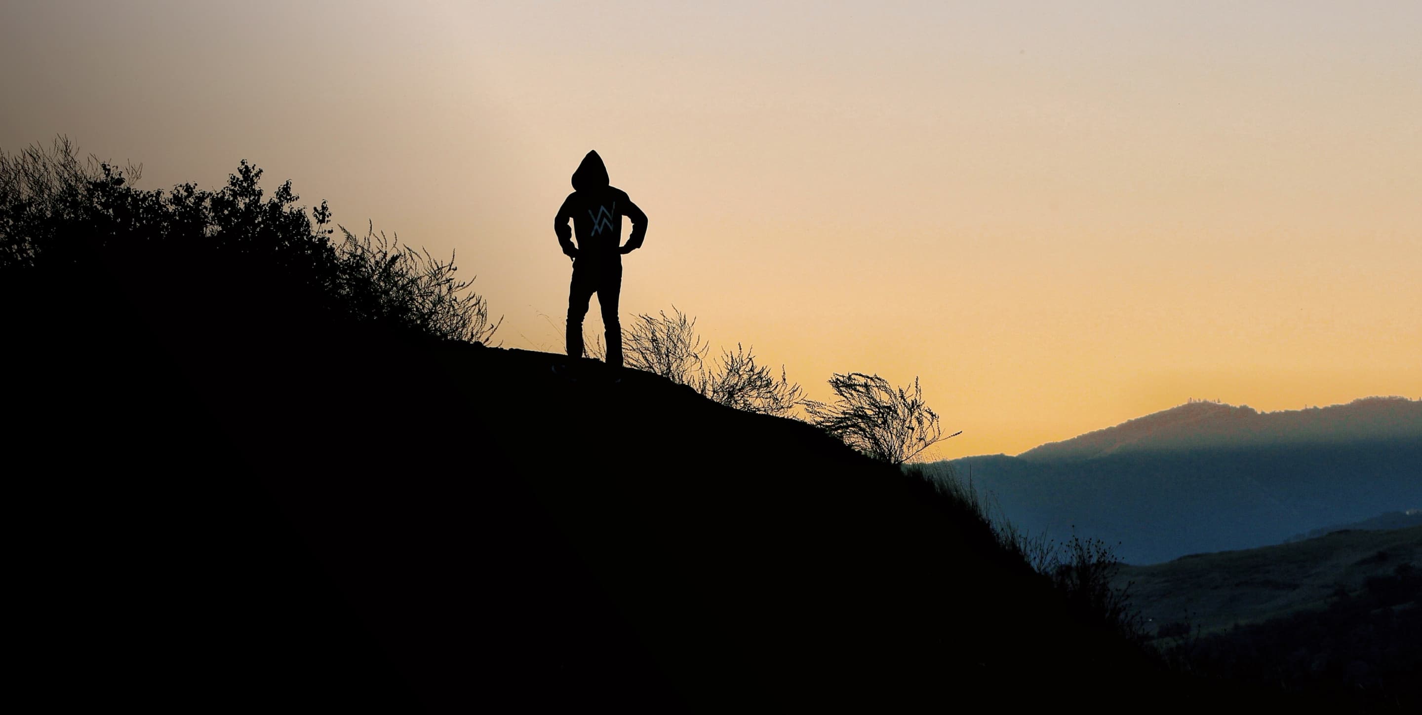Two cyclists walking their bikes across a wooden bridge.